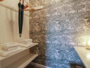 a bathroom with towels and an umbrella on a wall at North Segganwell - Culzean Castle in Maybole +56 photos