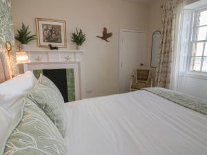 a bedroom with a white bed and a fireplace at North Segganwell - Culzean Castle in Maybole