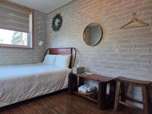 a bedroom with a bed and a table with a mirror at Sokcho Hutte in Sokcho