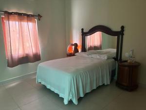 a bedroom with a bed with a wooden headboard at Casa mahana in Pisté