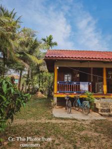 a house with a bike parked in front of it at Noupad sunset Guesthouse in Don Det