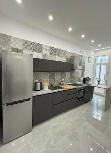 a kitchen with stainless steel appliances in a room at Aura - Luxury Suite in Syracuse