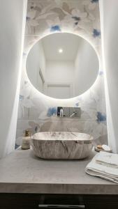 a bathroom with a large marble sink and a mirror at Aura - Luxury Suite in Syracuse