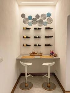 two stools in front of a counter with wine bottles at Aura - Luxury Suite in Syracuse