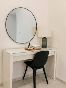 a white desk with a mirror and a black chair at Aura - Luxury Suite in Syracuse +8 photos