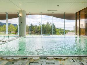 an indoor swimming pool with a large window at Shiretoko Daiichi Hotel in Shari