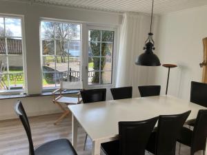a dining room with a white table and chairs at Hegedal Fjordhouse in Hobro