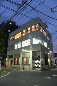 a building with a lot of windows on a street at Wharf Inn in Yokohama