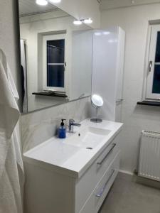 a white bathroom with a sink and a mirror at Hegedal Fjordhouse in Hobro +22 photos