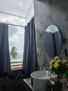 a bathroom with a tub and a mirror and a window at โรงแรมเลทุ่งแล่น 109 in Ban Phru Ching (1)