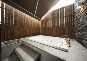 a bath tub in a bathroom with a wooden wall at Myeongdong Chungmuro Youngin Hotel in Seoul