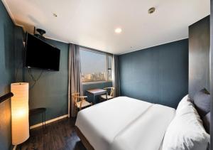 a hotel room with a bed and a large window at Myeongdong Chungmuro Youngin Hotel in Seoul
