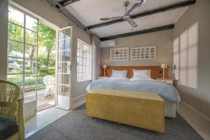 a bedroom with a bed and a large window at Graskop Hotel in Graskop