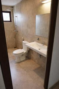 a bathroom with a toilet and a sink and a mirror at Walker's Residency in Anuradhapura
