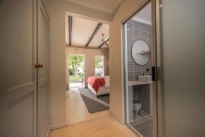 a hallway with a mirror and a room with a bed at Graskop Hotel in Graskop +117 photos