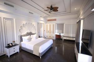 a bedroom with a bed and a flat screen tv at The Surya Golden Palace, Pushkar in Pushkar
