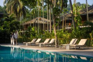 a couple standing next to a pool at a resort at Tilar Siro Andamans - A CGH Earth Experience in Havelock Island