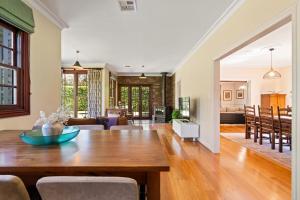 a dining room and living room with a wooden table at Chestnut Tree Farm in Werai