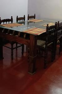 a large wooden table with chairs around it at Quiet Canopy homestay in Padinjarathara