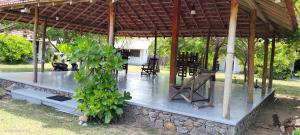 a pavilion with a table and chairs and a plant at windy beach kite resort in Kalpitiya