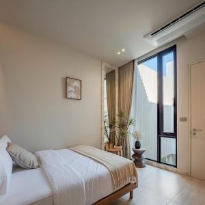a bedroom with a bed and a large window at POV Pool Villas in Ko Larn