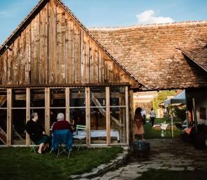 a group of people sitting in chairs outside of a barn at Șura din Seleuș - Seleuș Barn - Idyllic Countryside M Museum House in Sighişoara