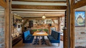 a dining room with a wooden table and blue chairs at Șura din Seleuș - Seleuș Barn - Idyllic Countryside M Museum House in Sighişoara