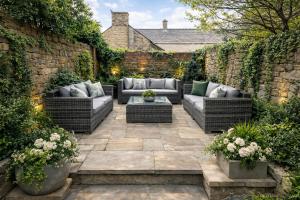 a patio with couches and a brick wall at The Garden Hideaway Central Corbridge in Corbridge