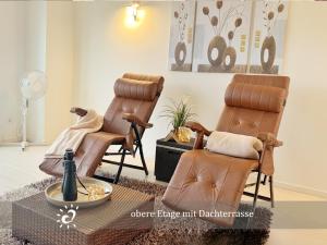 two massage chairs and a table in a living room at Ferienwohnung de Lark Penthouse mit Nordseeblick in Dorum-Neufeld +20 photos