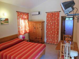 a bedroom with a bed and a table and a television at Casa Lily & Coco in Las Terrenas