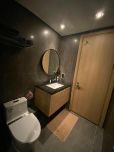 a bathroom with a toilet and a sink and a mirror at Paradis Homestay Marina Ha Long in Ha Long