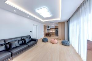 a living room with a black couch and two bean bags at The Bay Jeju Resort in Seogwipo