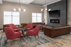 a waiting room with red chairs and a fireplace at Hilton Garden Inn Topeka in Topeka