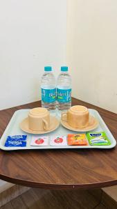 two bottles of water and two hats on a tray at Villa The De Grise in Pondicherry