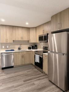 a kitchen with stainless steel appliances and wooden cabinets at Casa Gabriel in YYC
