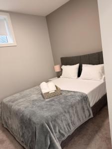 a bedroom with a bed with a gray blanket at Casa Gabriel in YYC
