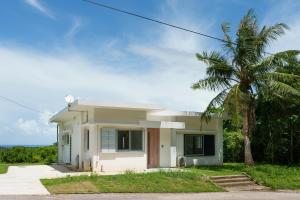 a small white house with a palm tree at Palm Hills in Ishigaki Island
