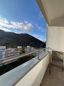 a balcony with a chair and a view of a building at Apartmánový byt VYHNE in Vyhne