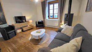 a living room with a couch and a table at Maison cosy 4-6 pers avec terrasse Lac & hyper centre à pied 300 m Linge inclus in Gérardmer