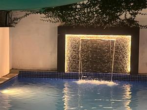 a swimming pool with a water fountain at Villa The De Grise in Pondicherry