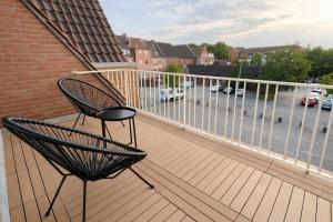 a balcony with a chair and a view of a parking lot at Emden City Center - Innenstadt in Emden