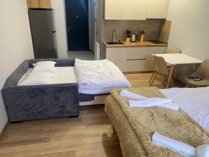 two beds in a small room with a kitchen at Cozy apartment Dvali in Bakuriani