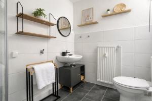 a bathroom with a toilet and a sink at Emden City Center - Innenstadt in Emden +27 photos