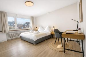 a bedroom with a bed and a desk and a desk at Emden City Center - Innenstadt in Emden