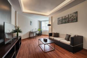 a living room with a couch and a tv at Bentani Hotel & Residences Cirebon in Cirebon