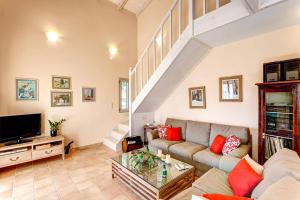 a living room with a couch and a tv at Villa Olive Grove by Villa Plus in Marathi