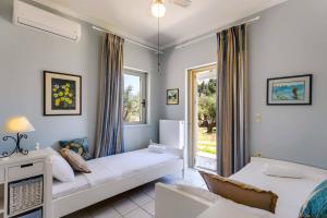 a living room with a bed and a window at Villa Olive Grove by Villa Plus in Marathi +30 photos