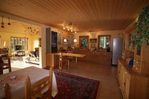 eine Küche und ein Wohnzimmer mit einem Tisch und einem Kühlschrank in der Unterkunft Ferienhaus Sonne, Harz und Sterne in Hohegeiß