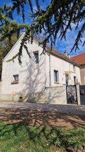 a large white building with a tree in front of it at Maisons Vaudésir - Rose, Chablis in Chablis