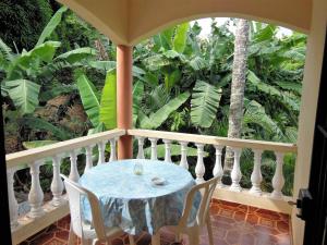 a table and chairs on a balcony with trees at Casa Lily & Coco in Las Terrenas